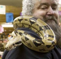man with large snake on shoulder