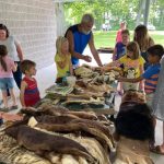 man and kids with animal pelts