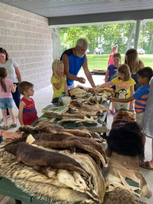 man and kids with animal pelts